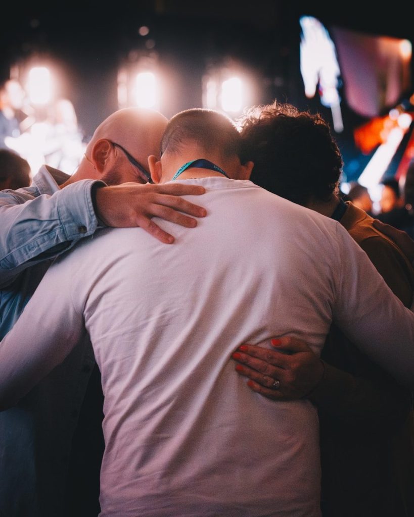 A group of people hugging each other at a concert