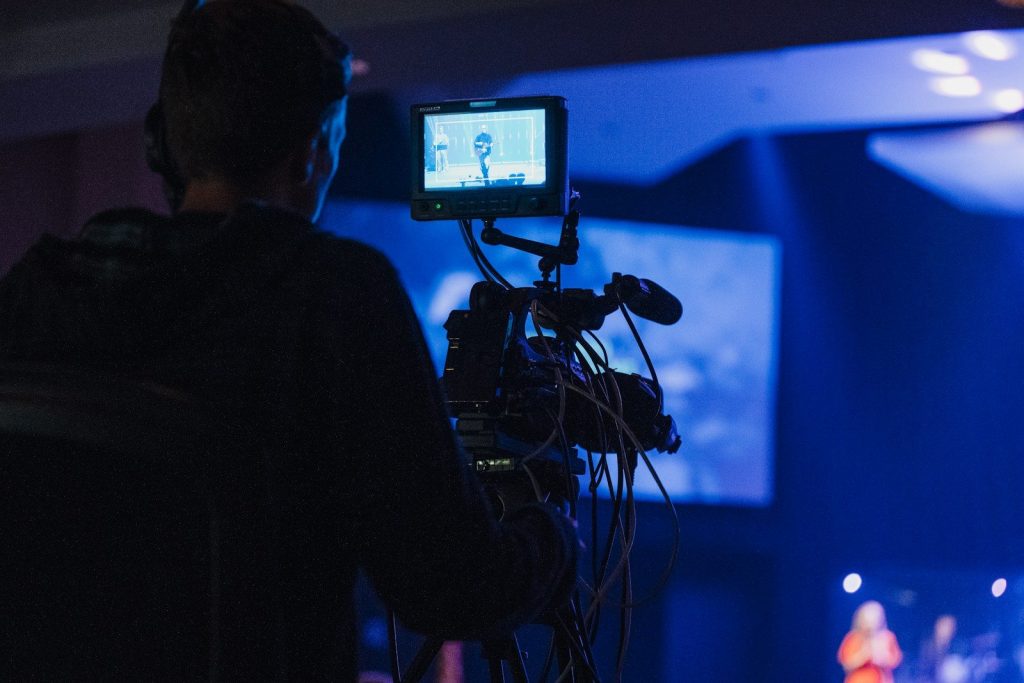 A man standing in front of a camera on a stage